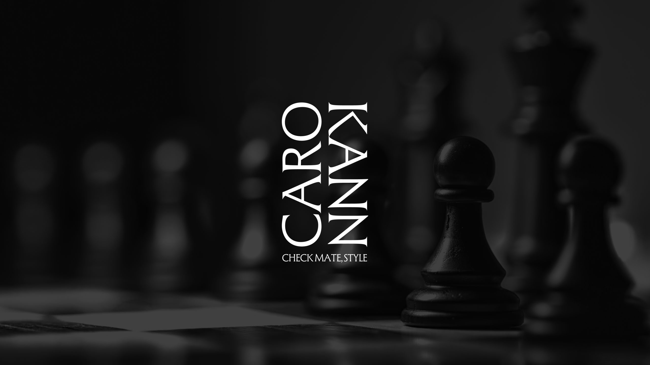 La marca de Caro Kann sobre un fondo difuminado en blanco y negro de figuras de ajedrez. La marca está a pluma y las palabras Caro y Kann están escritas en vertical. Caro de abajo a arriba y Kann de arriba a abajo. Bajo ambas puede verse el claim "Check mate, style"
